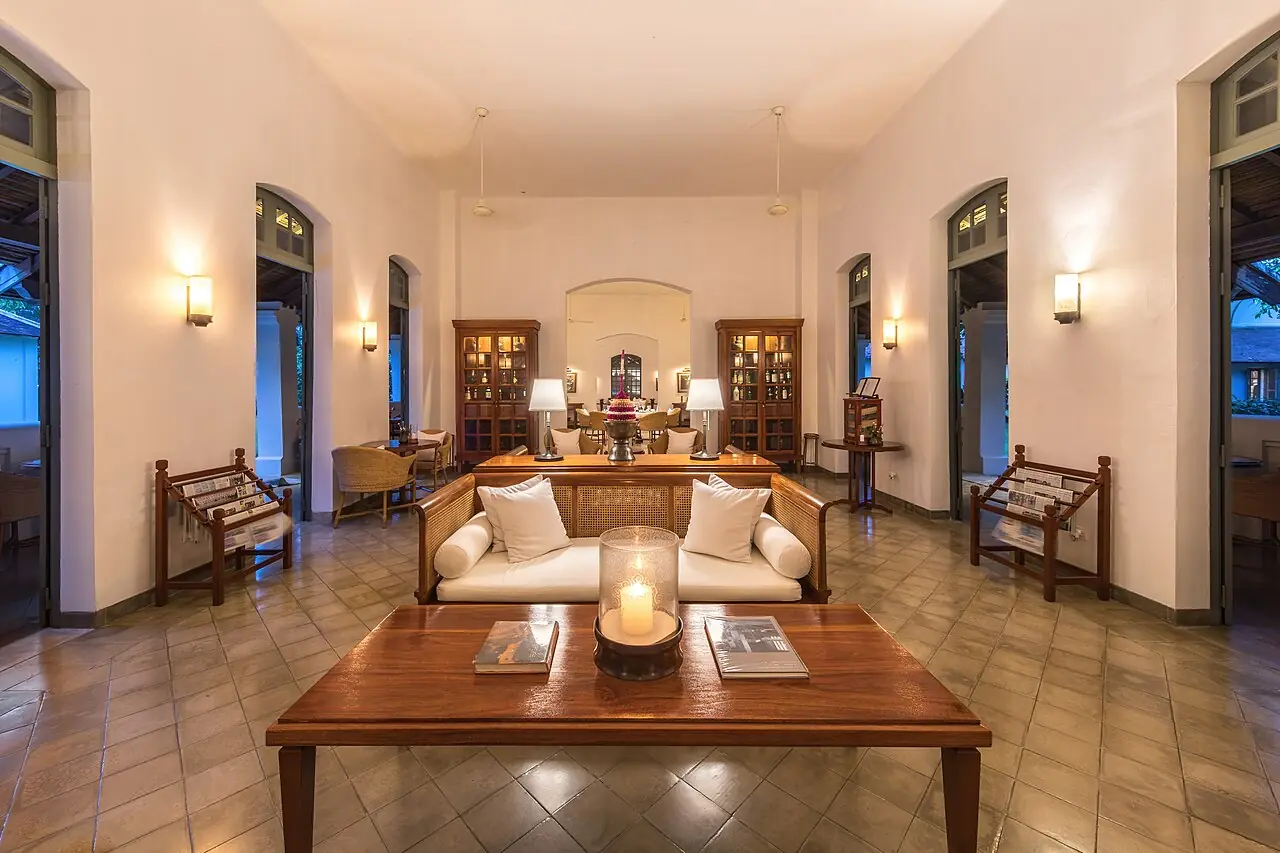 Reception lounge at Amantaka luxury resort and hotel at blue hour in Luang Prabang , Laos , with couch and a candle lantern on the low table