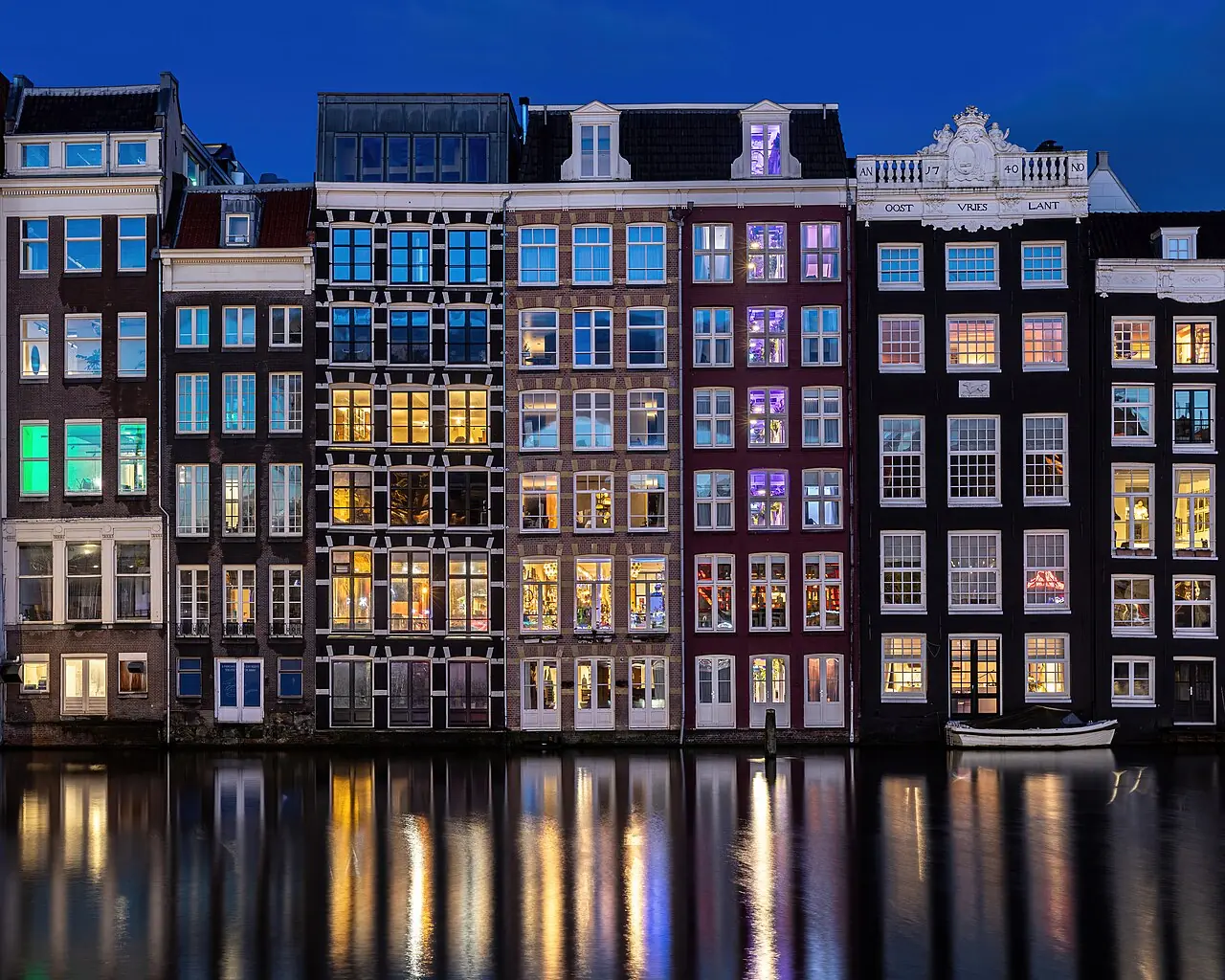 Water reflection of colorful windows of canal houses , east side, where the houses are located directly on the water, front view, at blue ho
