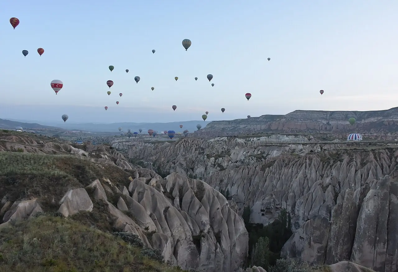 Hot air balloons over valleys near Göreme at dawn
